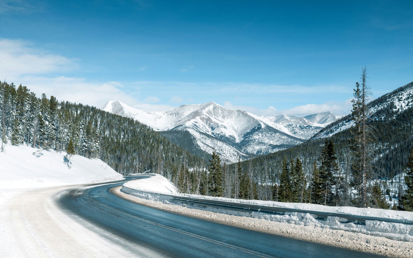 Snow-covered mountain road for winter travel planning in Colorado